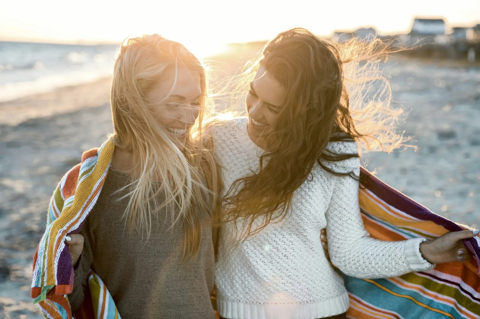 Amiche che ridono al tramonto