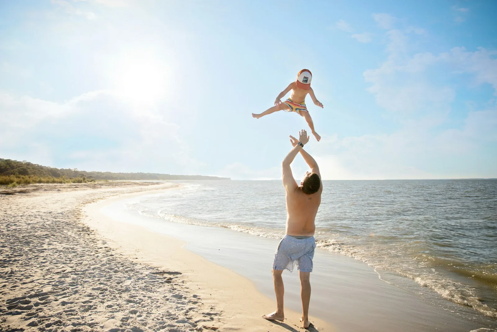 Papà che gioca con il bambino in spiaggia