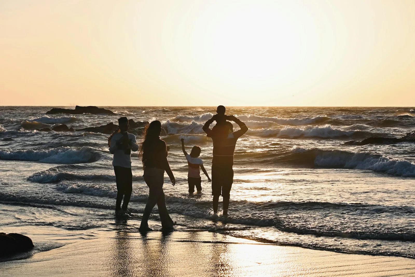 Famiglia in spiaggia al tramonto
