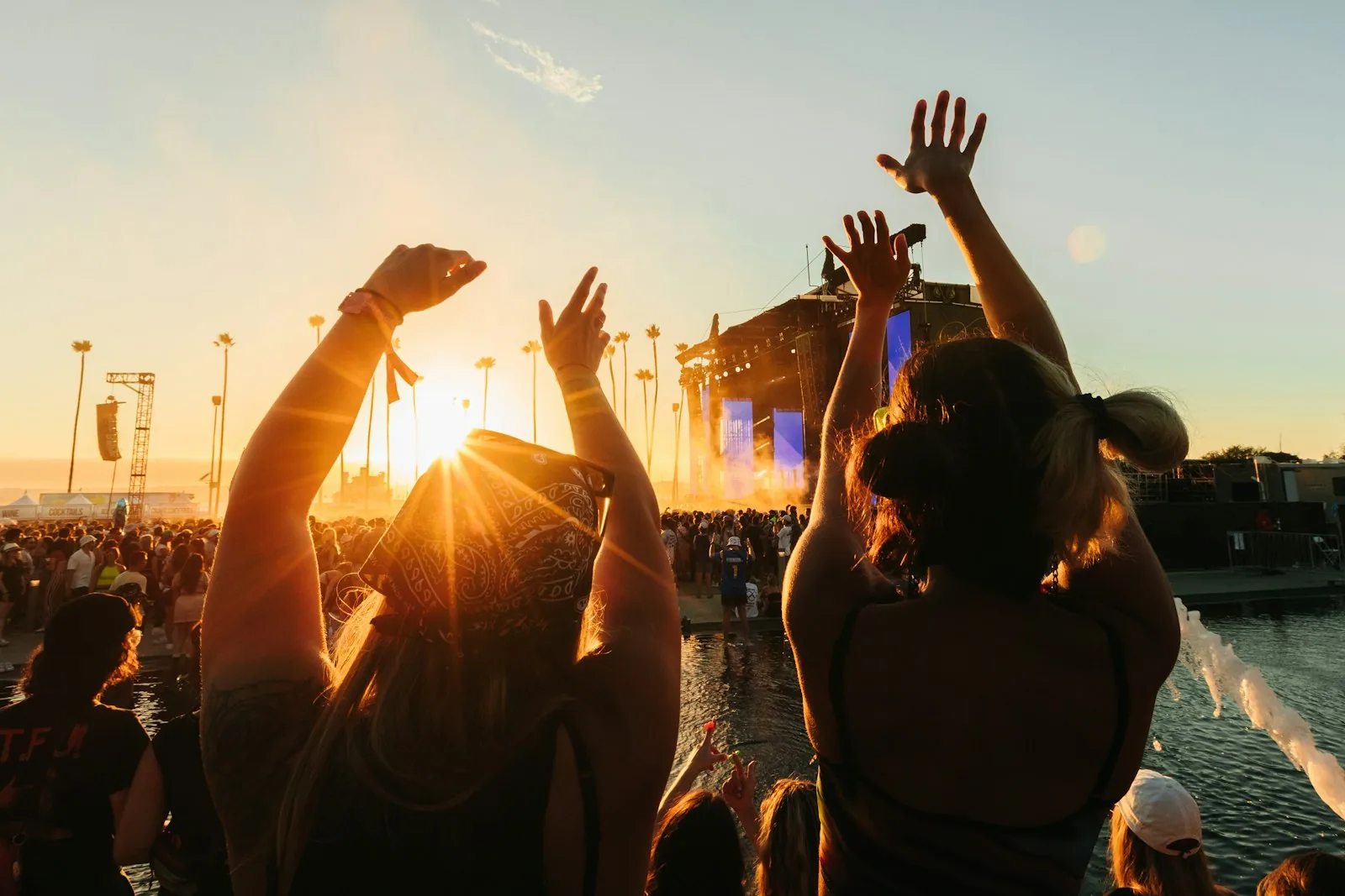 Mani alzate al tramonto durante un festival